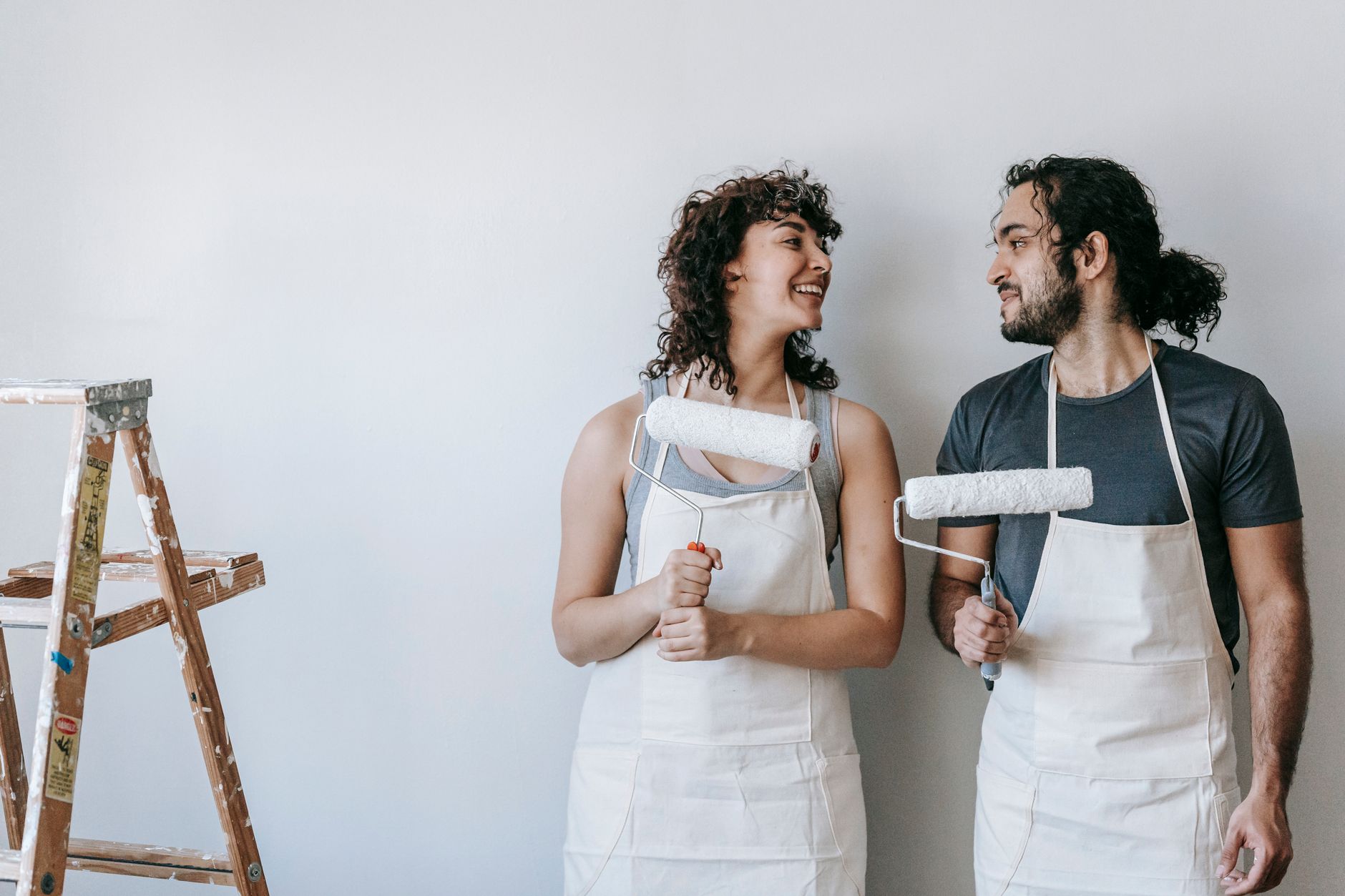 Happy couple enjoying a home renovation project, painting walls together indoors in Pasadena, CA